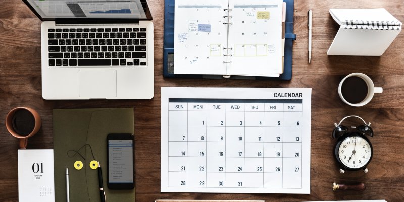 Desk top with calendar, computer and clock